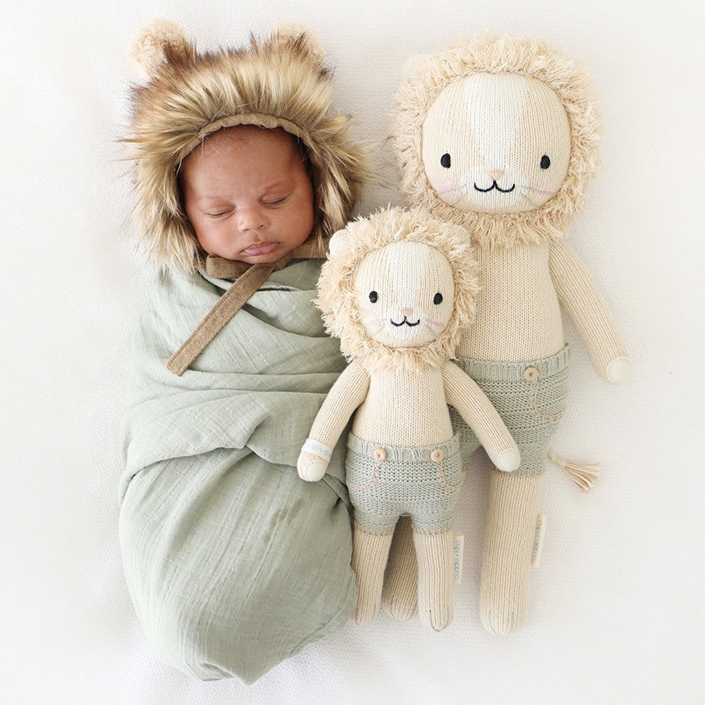 Newborn baby sleeping next to Cuddle and Kind Sawyer the Lion