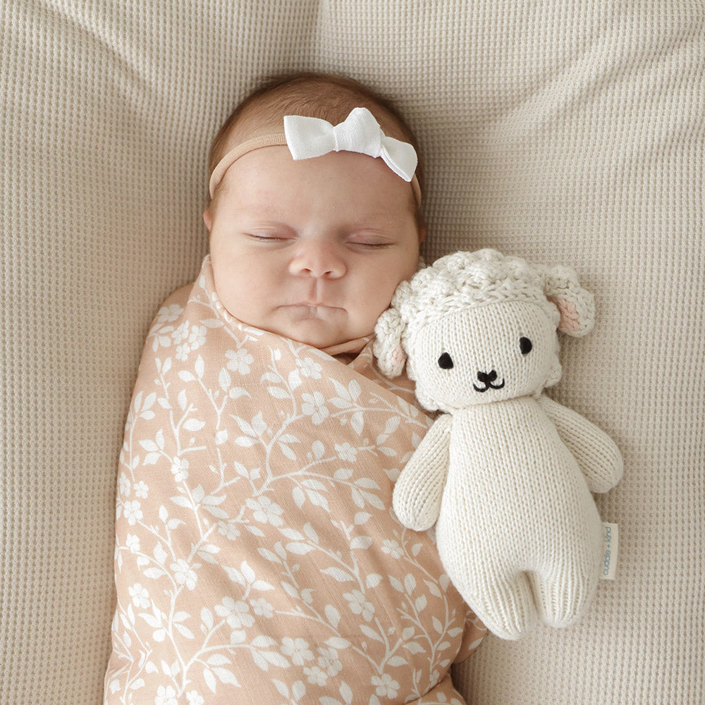 Baby sleeping next to Cuddle and Kind Baby Lamb - Cream