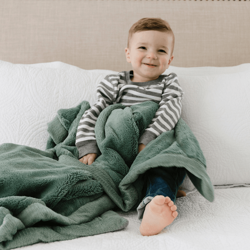 Little Boy Sitting with Saranoni Toddler Lush Blanket - Eucalyptus