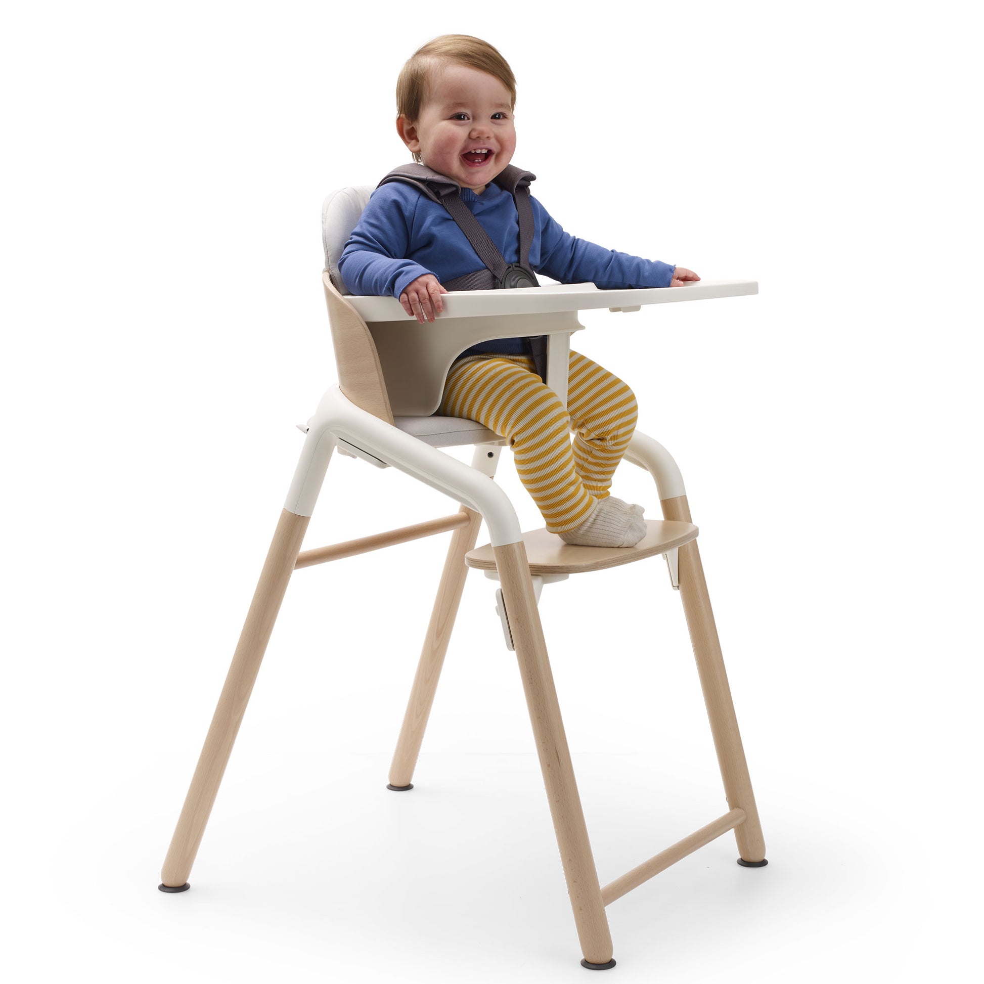 Baby sits in Bugaboo Giraffe High Chair Complete - Neutral Wood / White