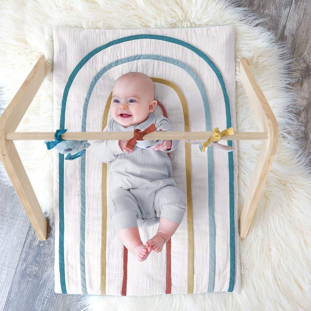 Baby laying on Itzy Ritzy Ritzy Activity Gym with Toys - Bitzy Bespoke