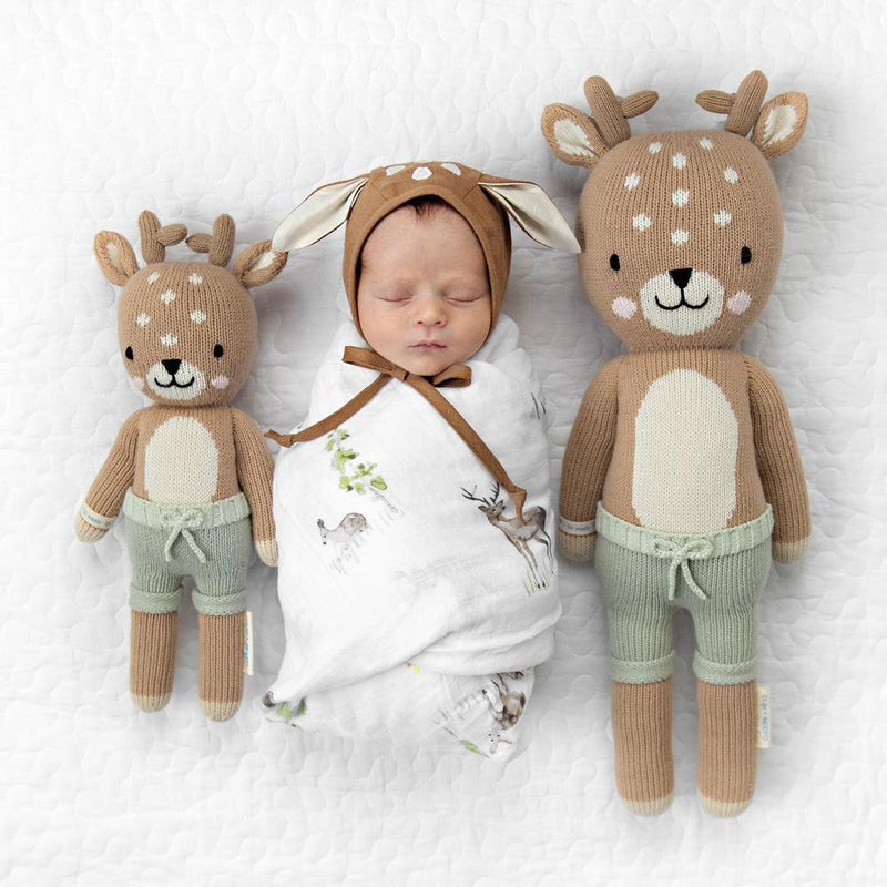 Newborn baby wearing deer bonnet and sleeping next to Cuddle and Kind Elliott the Fawn
