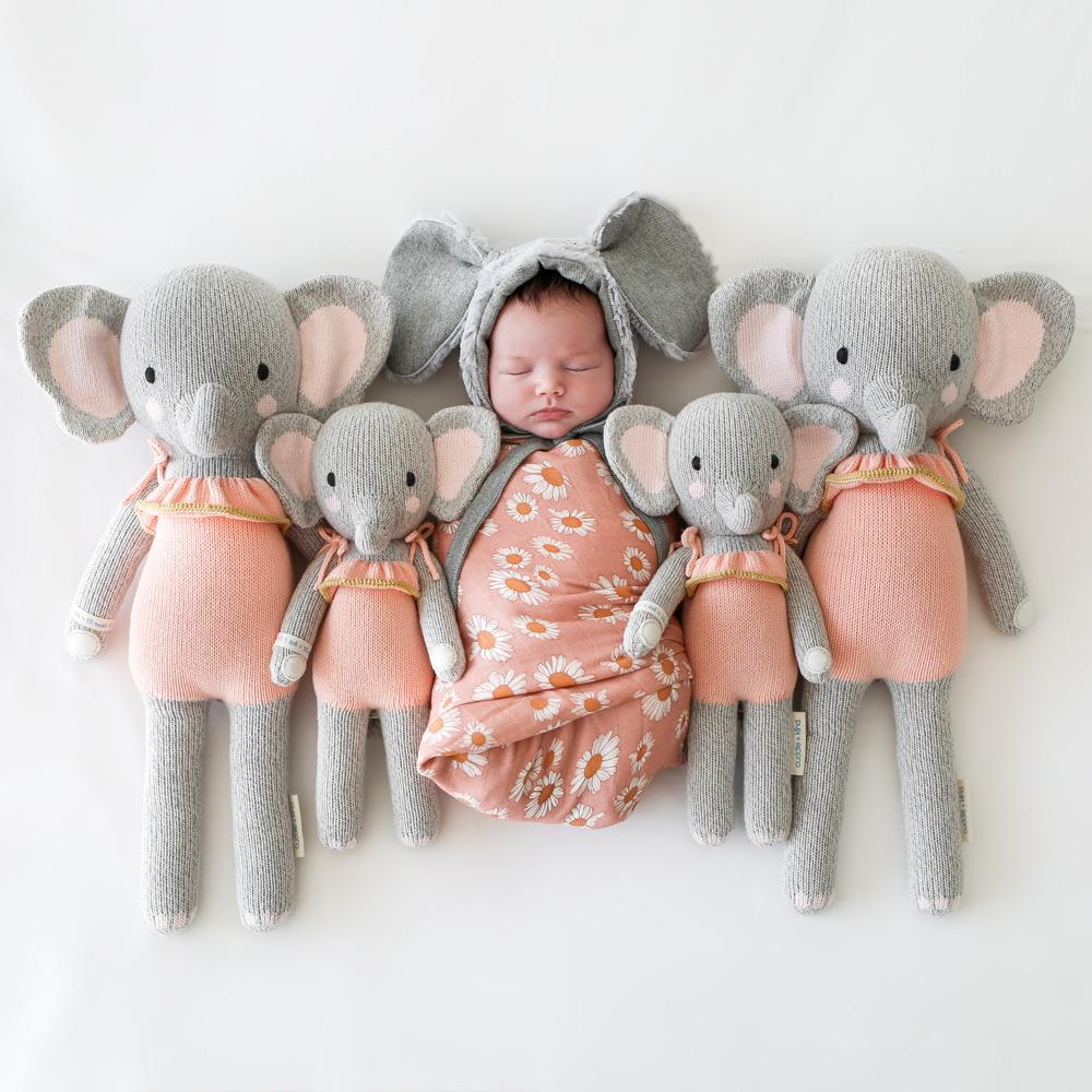 Newborn baby wearing elephant bonnet sleeping next to Cuddle and Kind Eloise the Elephant