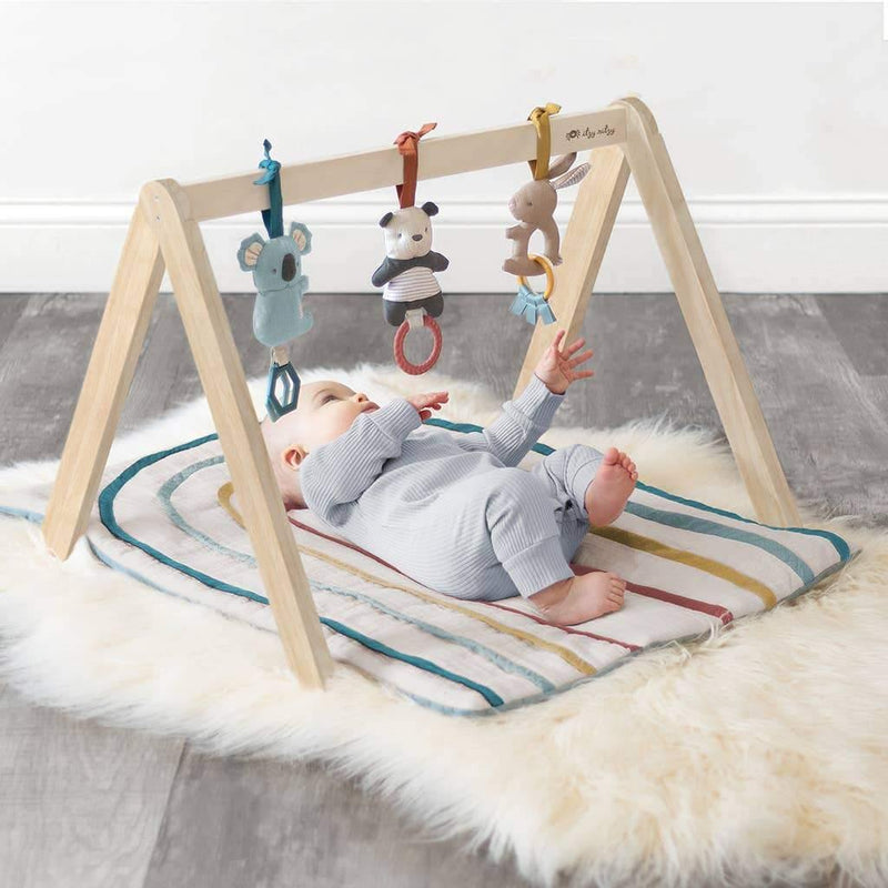 Baby laying on Itzy Ritzy Ritzy Activity Gym with Toys - Bitzy Bespoke