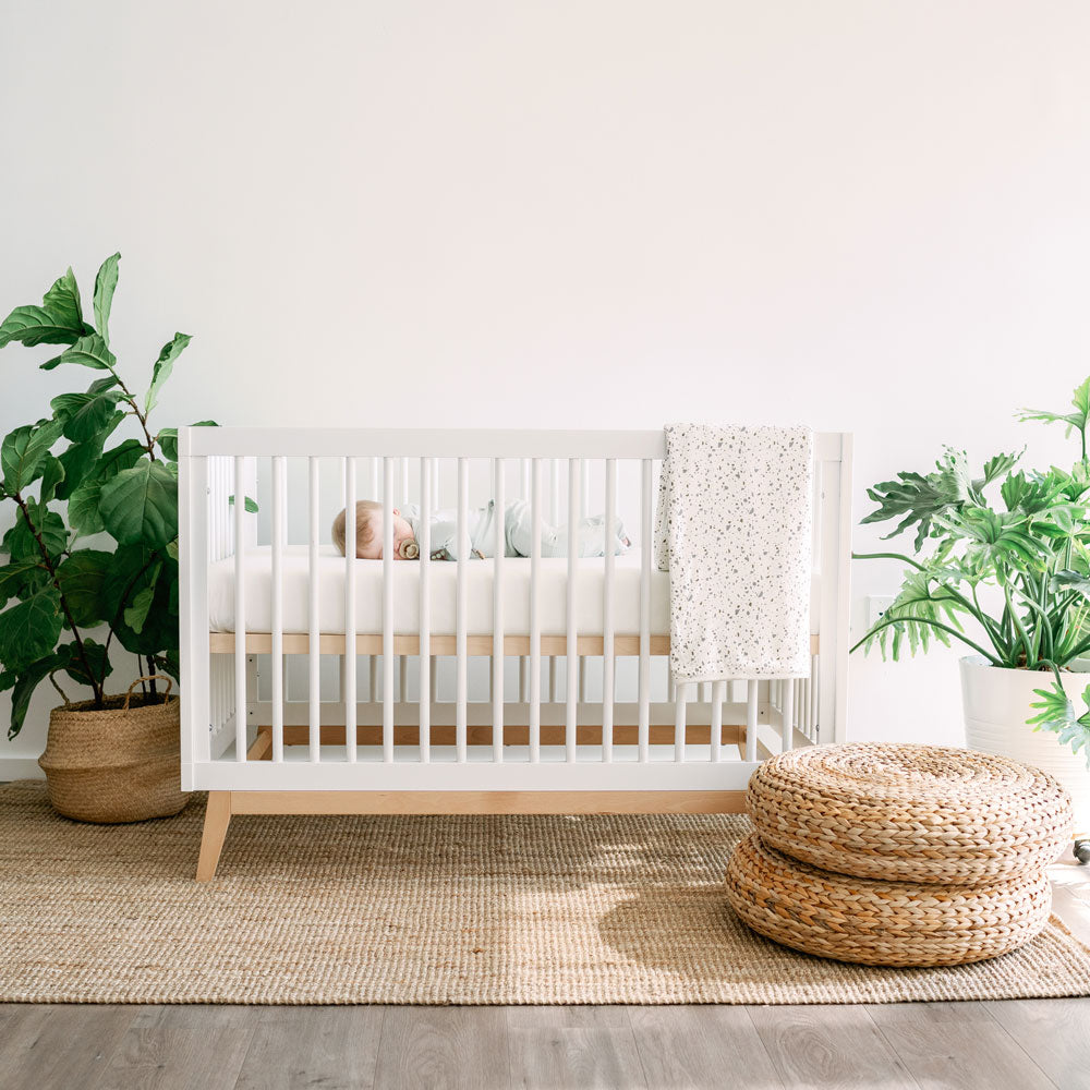 Baby sleeping in Dadada Soho 3-in-1 Convertible Crib - White / Natural