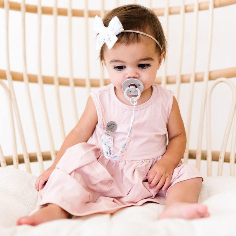 Baby girl using Copper Pearl Binky Clip Set - Bloom