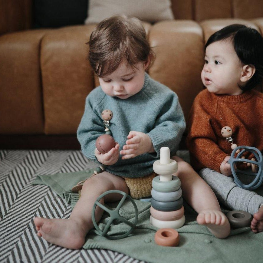 Babies playing with Mushie Ball Teether in Dried Thyme and Tradewinds