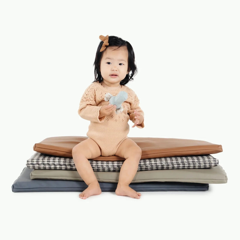 Little girls sits on stack of Gathre Padded Micro+ Mats