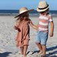 Boy wears Lovedbaby Kids' Slub Jersey Crewneck Tee - Adobe Stripe with girl on beach