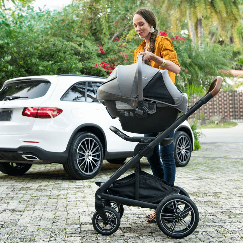 Woman using the Nuna MIXX Next Stroller with Magnetic Buckle and PIPA RX Car Seat Travel System