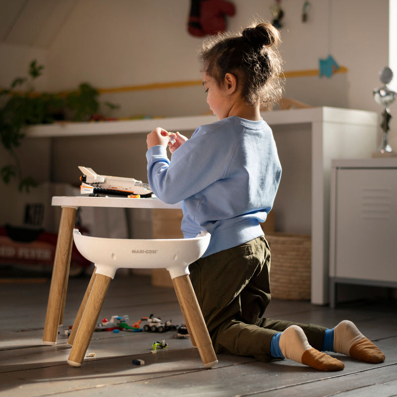 Child playing next to Maxi-Cosi Moa 8-in-1 High Chair