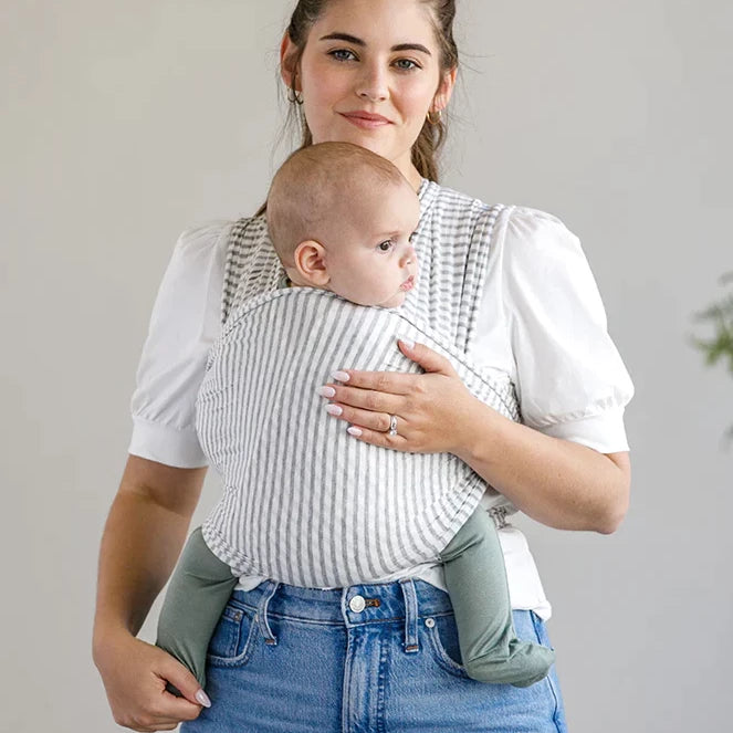 Woman wearing baby in Solly Baby Wrap - Natural and Grey Stripe