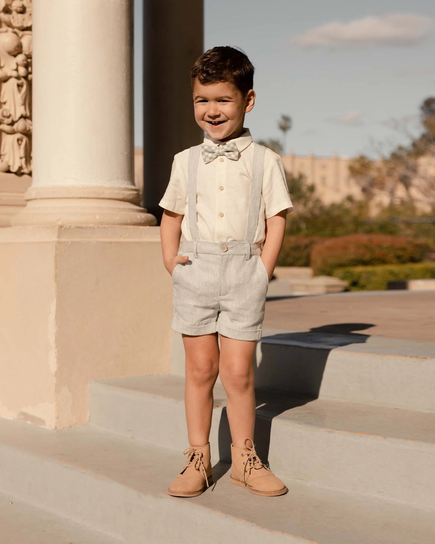 Boy wearing Noralee Atlas Shirt - Ivory and suspender shorts