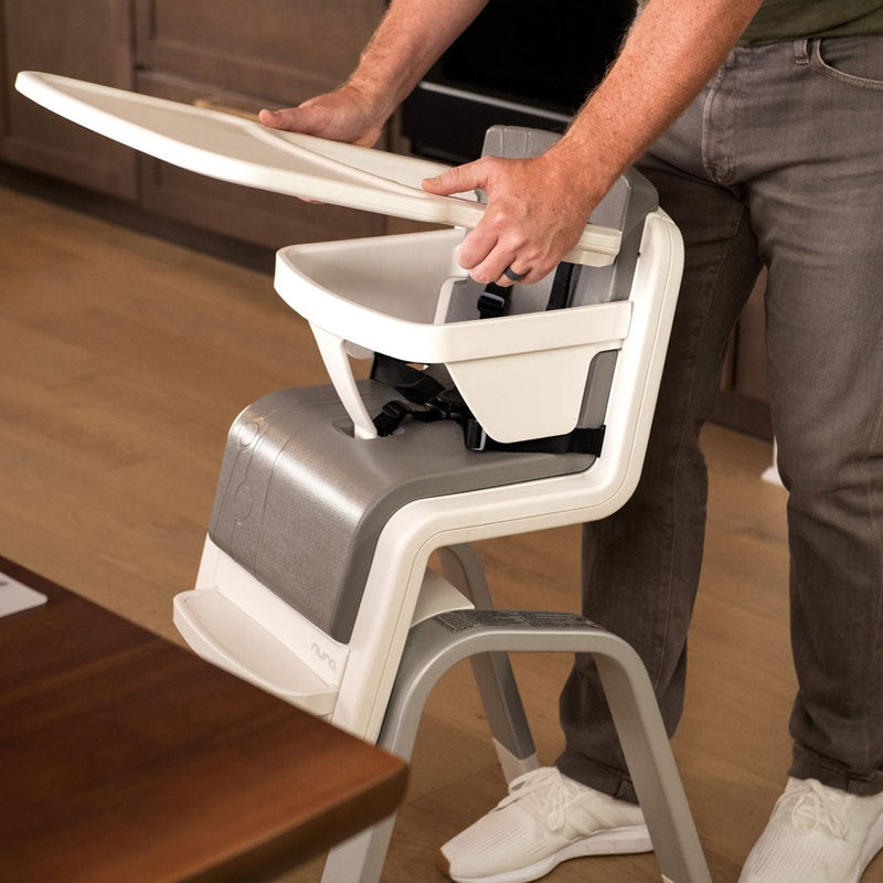 Dad putting tray onto Nuna ZAAZ High Chair with MagneTech Secure Snap
