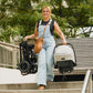 Woman carries Nuna TRIV Next Stroller and pipa car seat