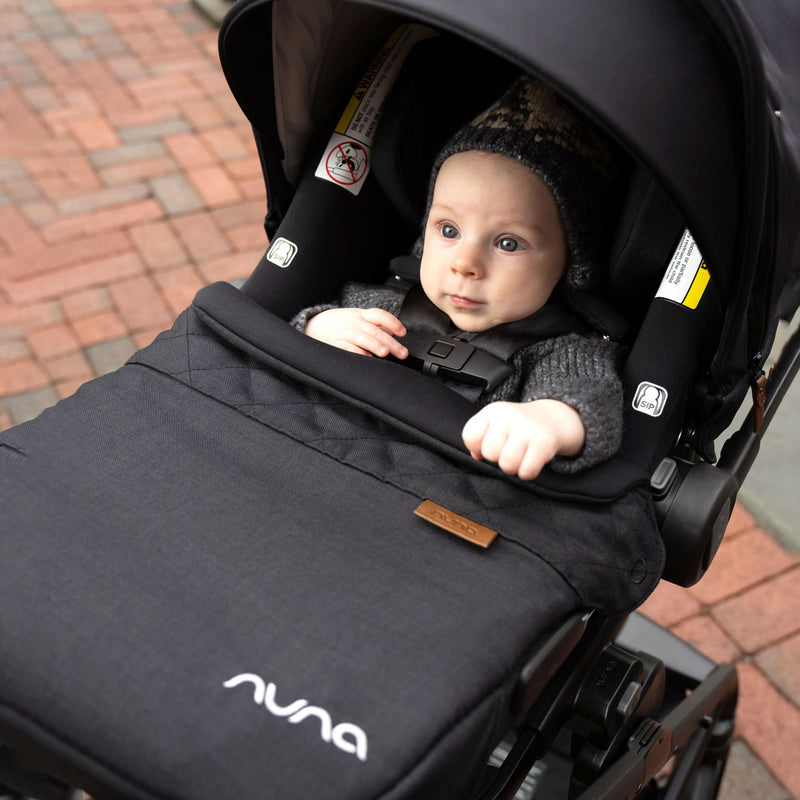 Baby rides in stroller with Nuna PIPA Lite RX Footmuff - Caviar