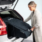 Woman placing Nuna Wheeled Travel Bag - Indigo into vehicle