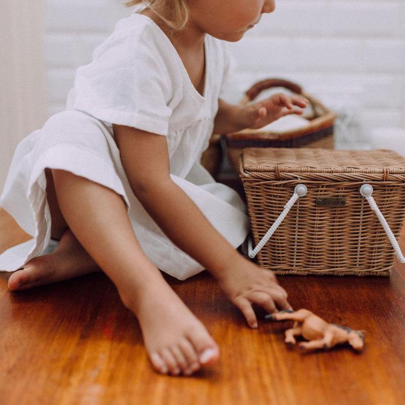 Toddler sitting with Olli Ella Piki Rattan Basket - Natural 