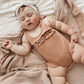 Baby girl wears Lovedbaby Ruffle Bodysuit - Adobe