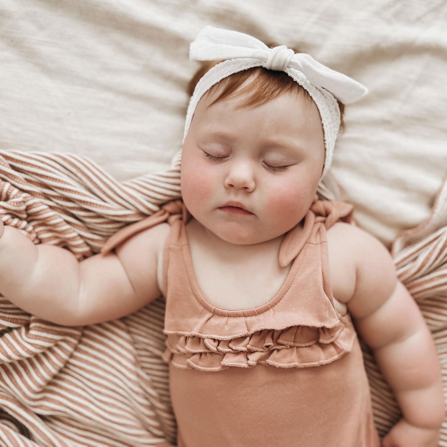 Baby girl wears Lovedbaby Ruffle Bodysuit - Adobe