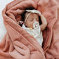 Baby sleeping wrapped in Saranoni Receiving Lush Blanket - Clay