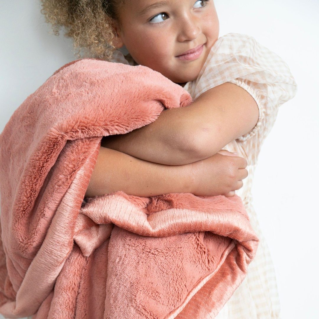 Little Girl holding Saranoni Toddler Lush Blanket - Clay