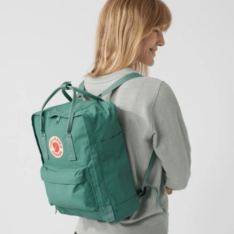 Woman wearing Fjallraven Kanken Classic Backpack - Frost Green