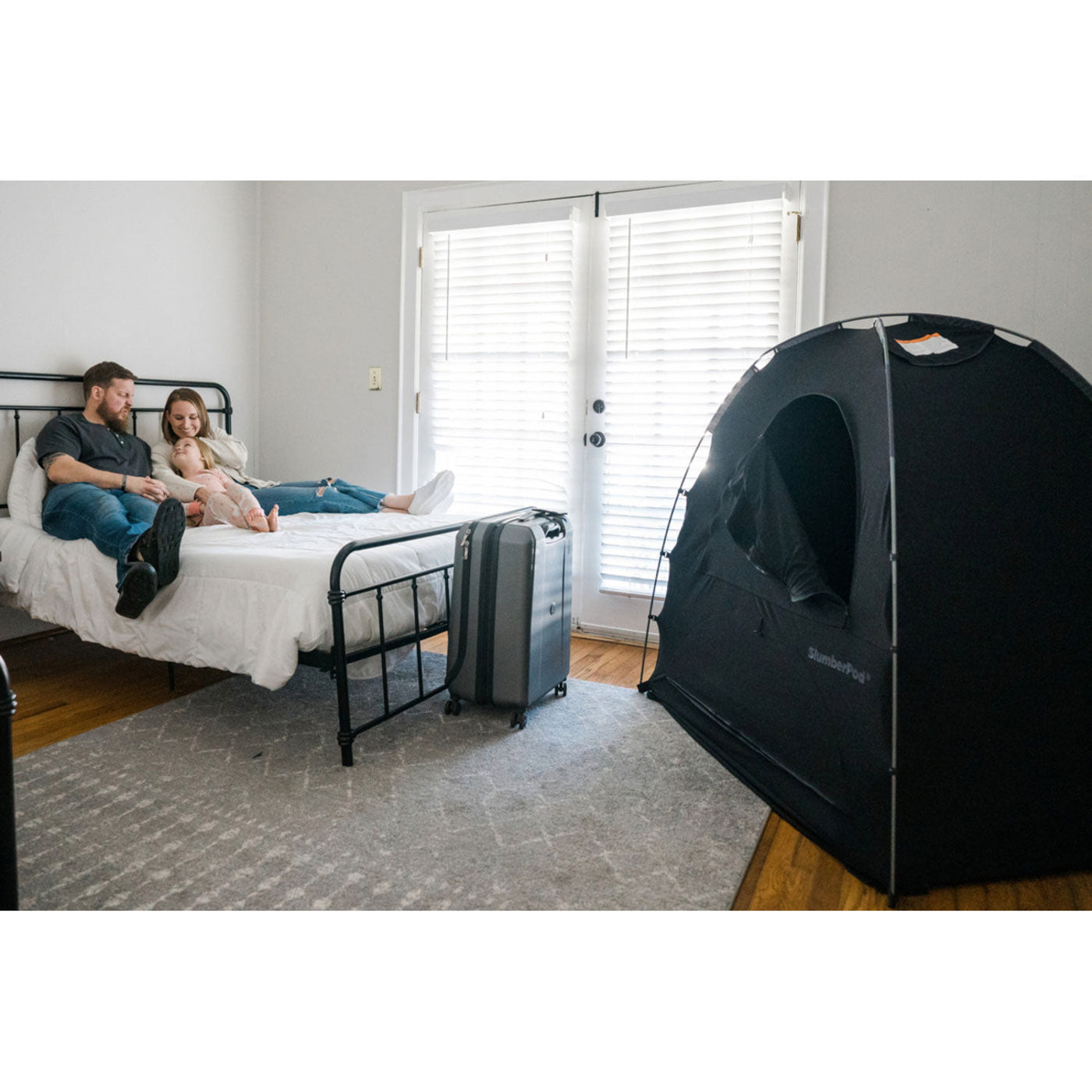 Family on bed with SlumberPod Privacy Pod - 3.0 in room