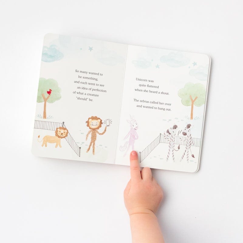 Child points to a page in Slumberkins Board Book - Unicorn Dares to be Unique: A Lesson in Authenticity