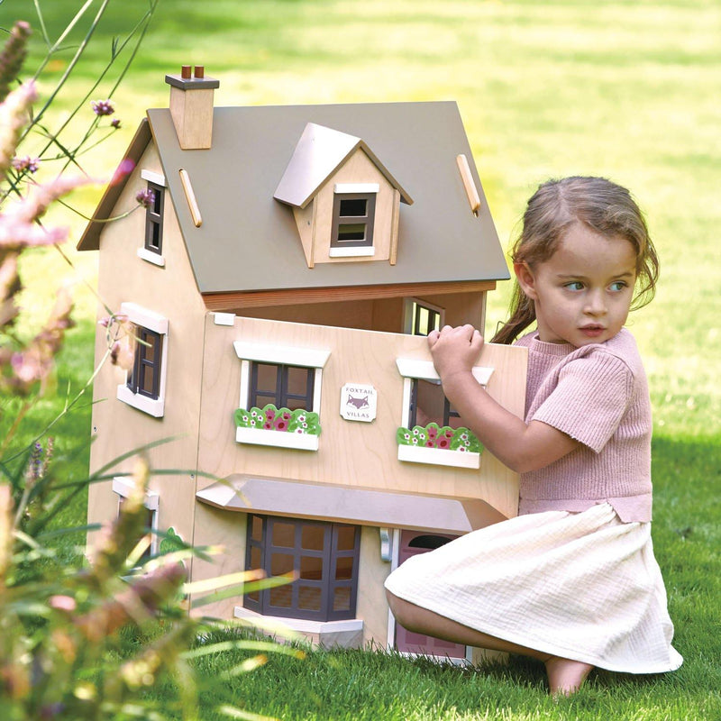 Little girl playing outside with Tender Leaf Toys Foxtail Villa Doll House