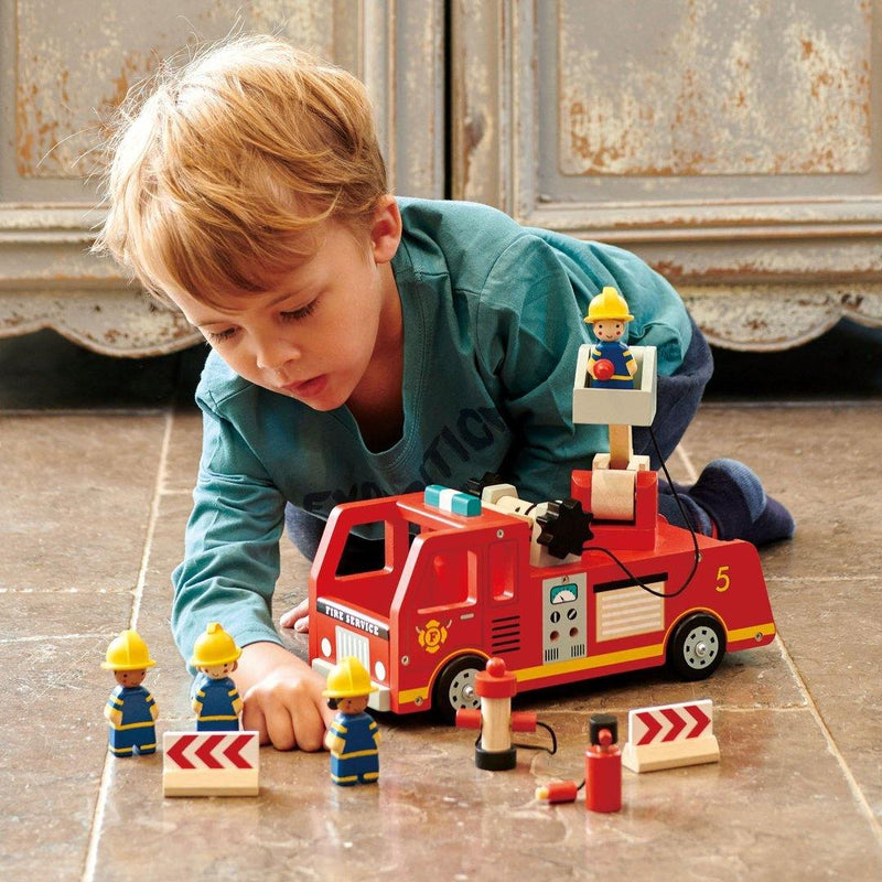 Little boy playing with Tender Leaf Toys Fire Engine