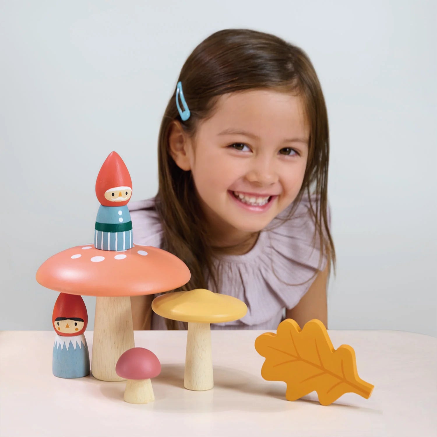 Girl poses with Tender Leaf Toys Woodland Gnome Family