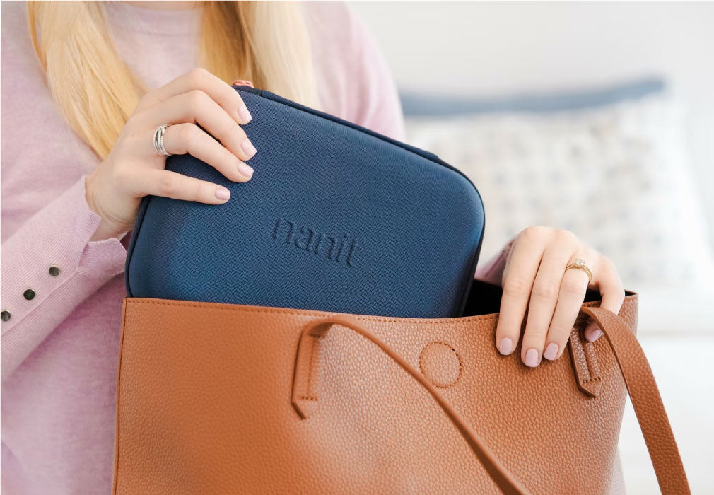 Woman putting Nanit Travel Case in her bag - Navy