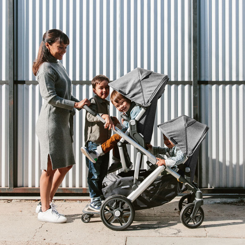 Woman uses UPPAbaby VISTA V2 Stroller in double mode with Piggyback
