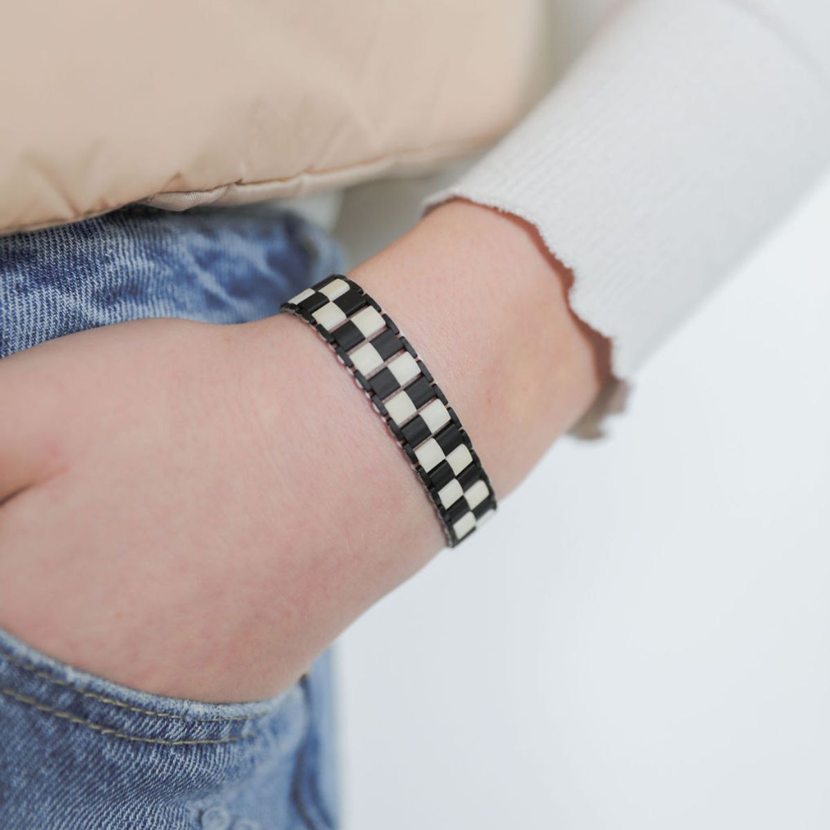 Closeup of woman wearing Simply Peri Checkered Bracelet - Black + Cream