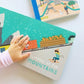 Child touching Lucy Darling All Aboard Primer Book