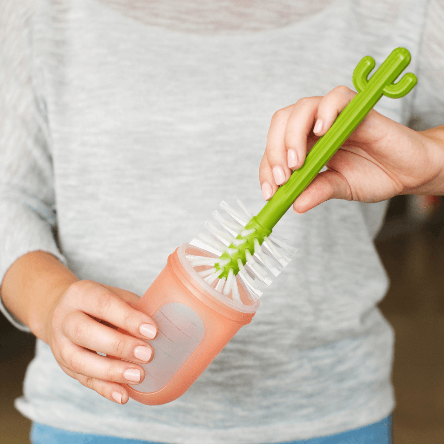 Woman using Boon CACTI Bottle Cleaning Brush Set - White/Green