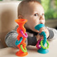 Child Playing with Fat Brain Toys PipSquigz Loops Suction Rattle Toy - Orange / Teal