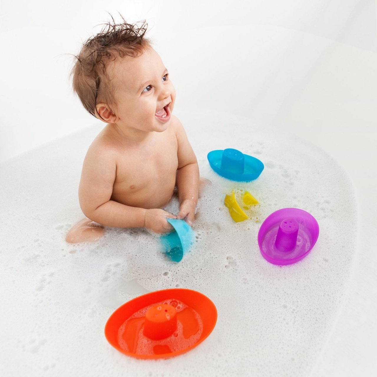 Child in Bath playing with Boon FLEET Stacking Boats - Navy / Multi