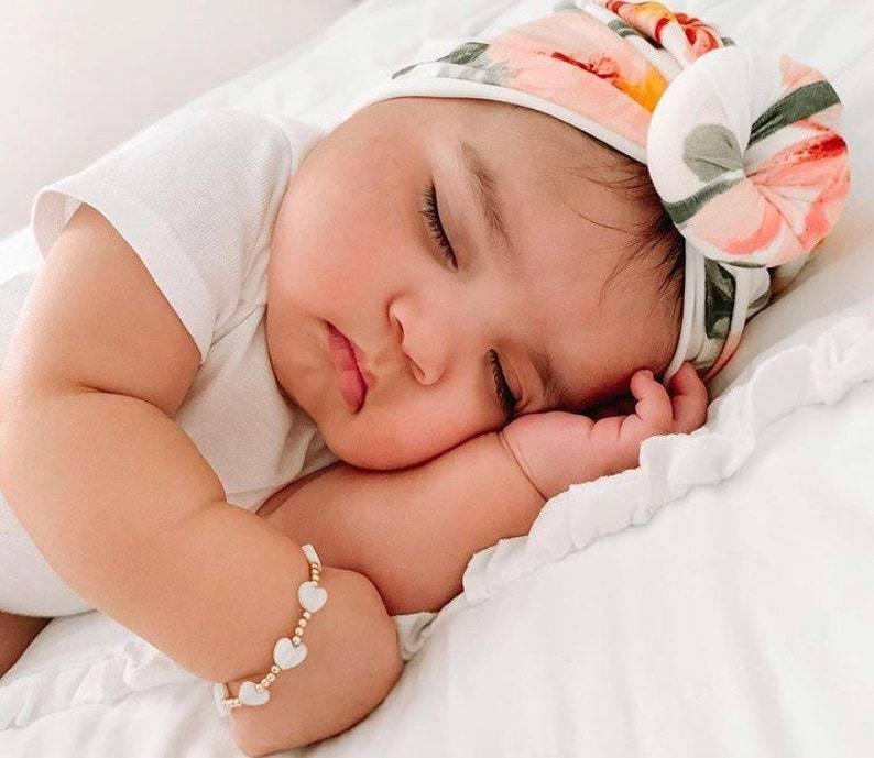 Baby wearing LittleLundsCo Baby Bracelet - White Heart