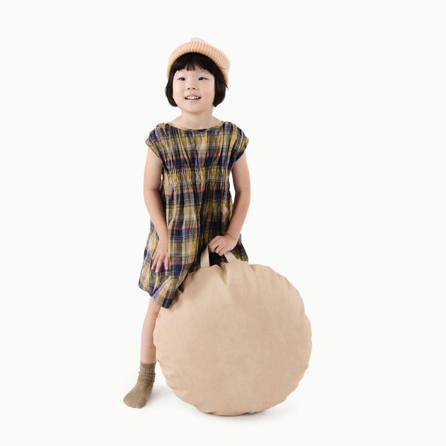 Little girl holds Gathre Mini Circle Floor Cushion - Untanned