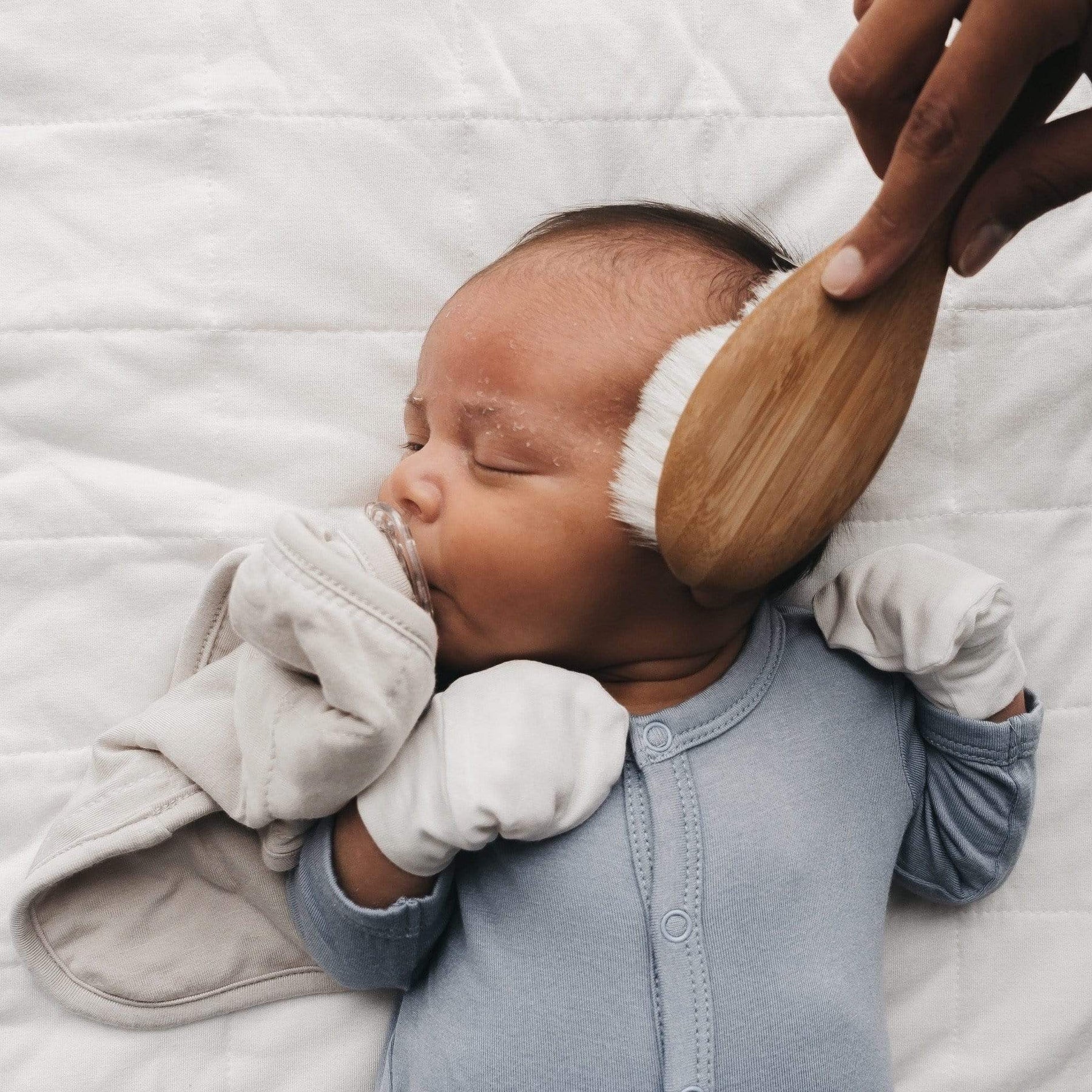 Baby being brushed with Kyte BABY Cradle Cap Brush - Bamboo