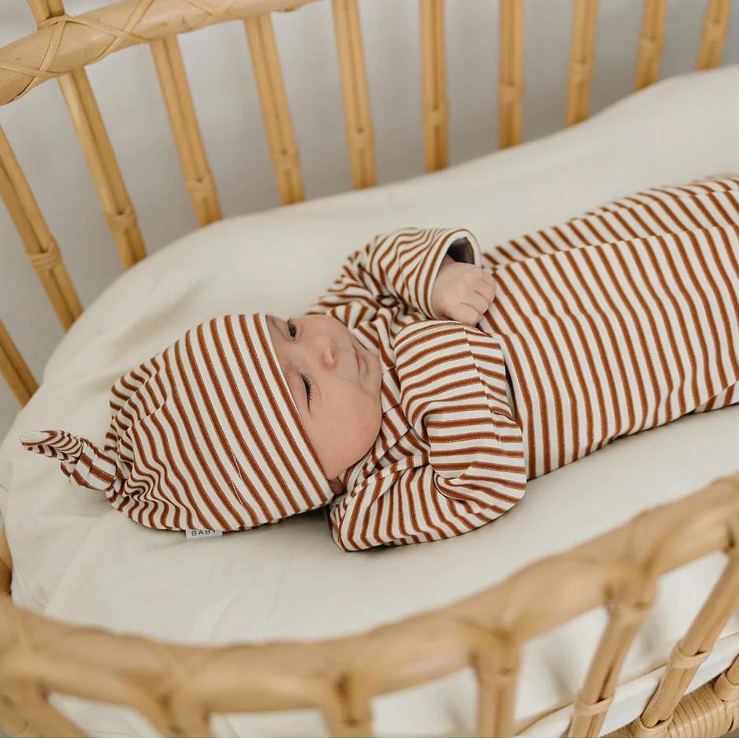 Baby wearing Mebie Baby Newborn Knot Hat - Rust Stripe
