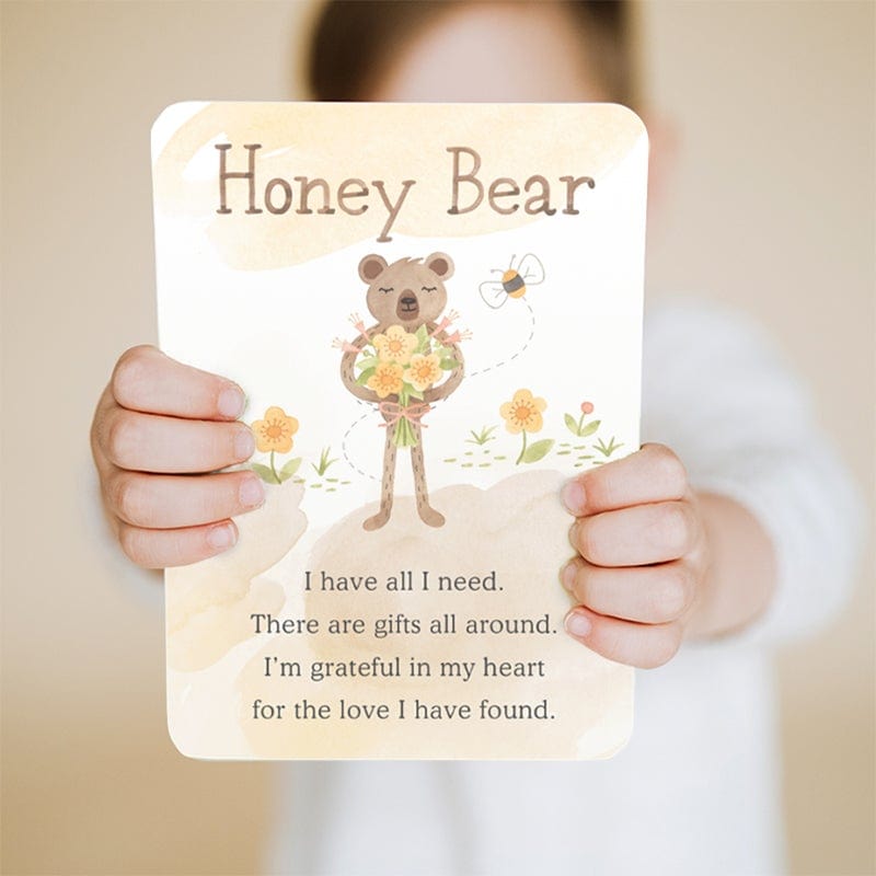 Child holding up affirmation card from Slumberkins Honey Bear Snuggler XL - Honey 
