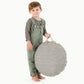 Little boy holds Gathre Mini Circle Floor Cushion - Stone Stripe